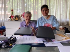 Two women receiving donated laptops